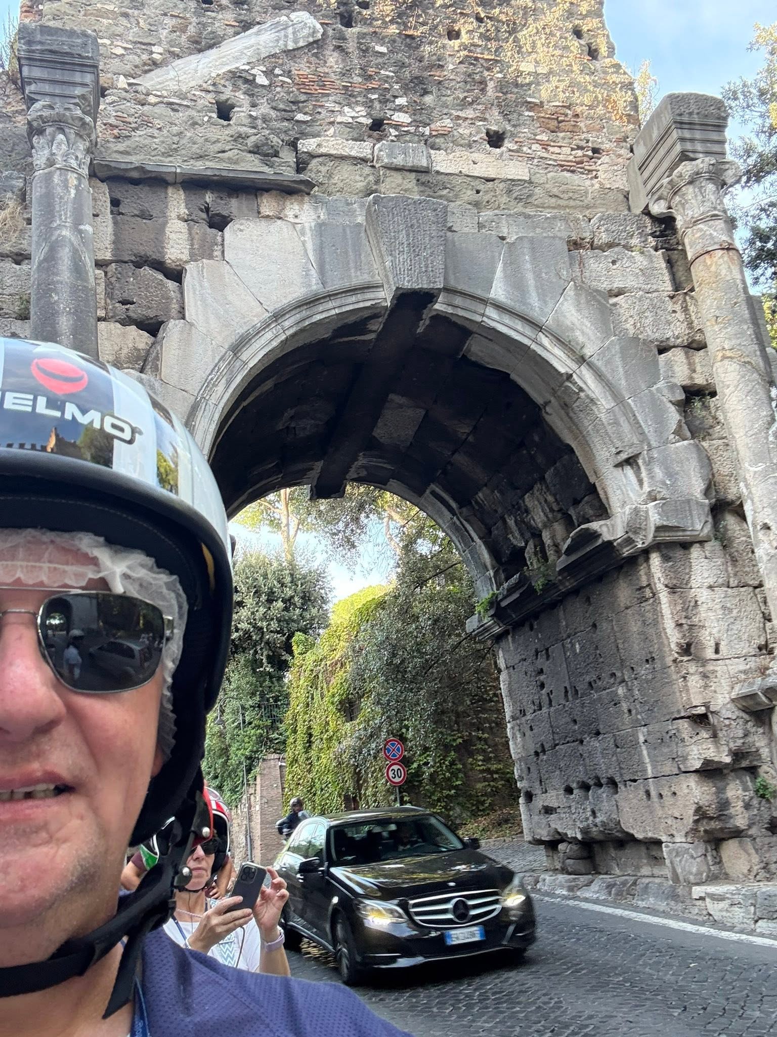 TM-Touring Gruppe mit Motorrollern vor einem antiken Stadttor in Rom