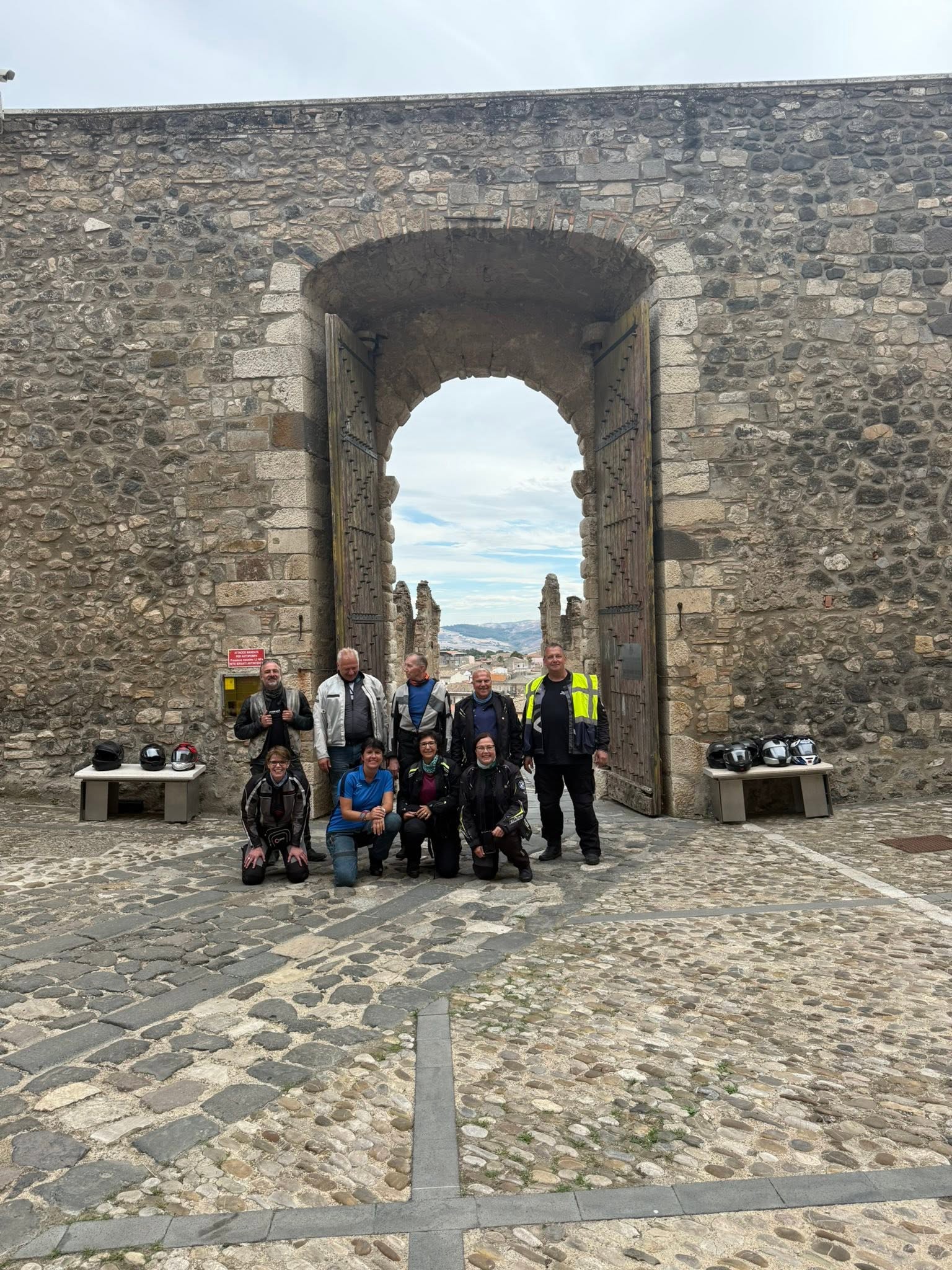 Motorradgruppe vor dem historischen Burgtor von Melfi