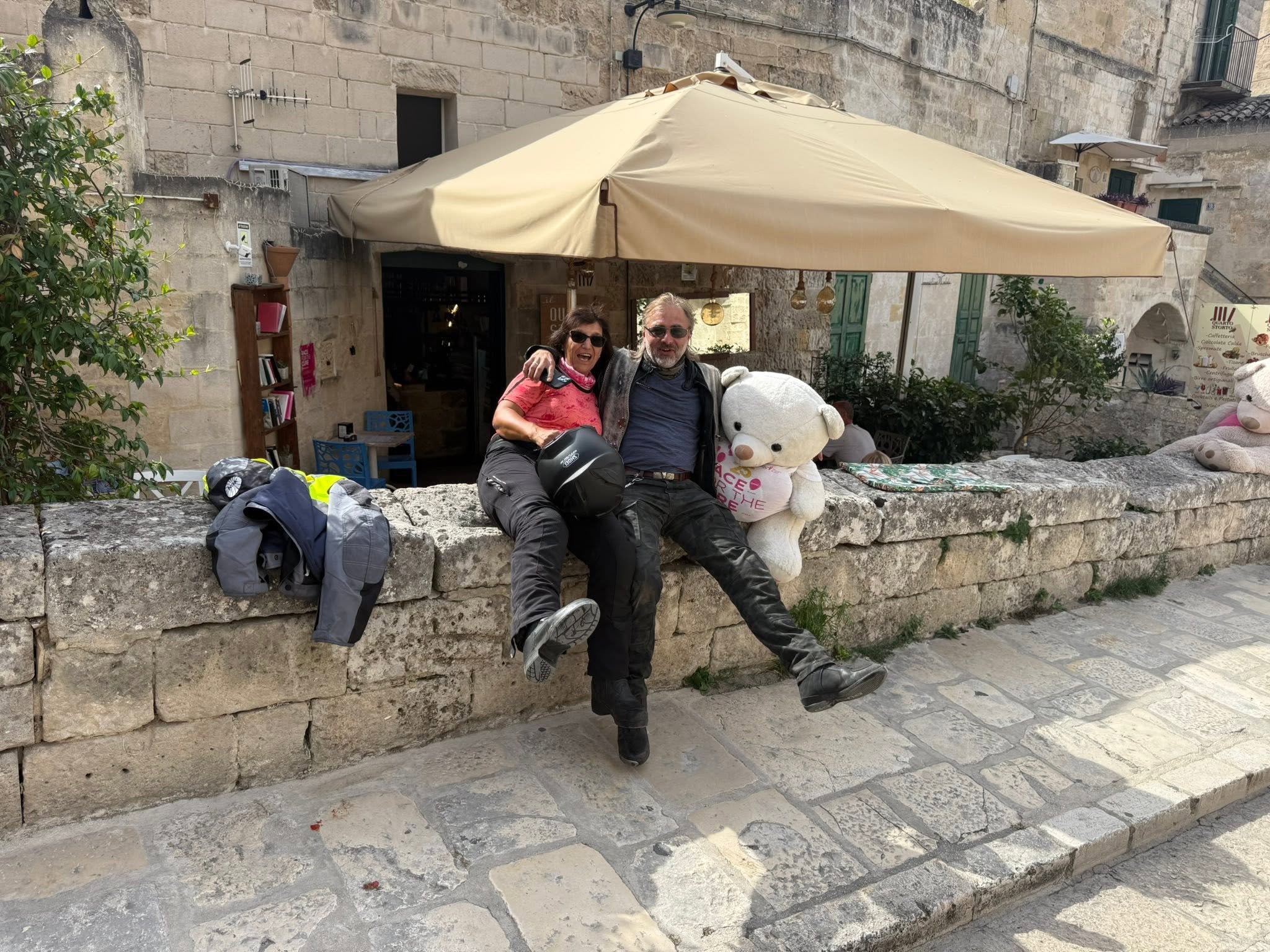 Eine Mitfahrerin und ein Mitfahrer mit einem großen weißen Stoffteddy in Matera