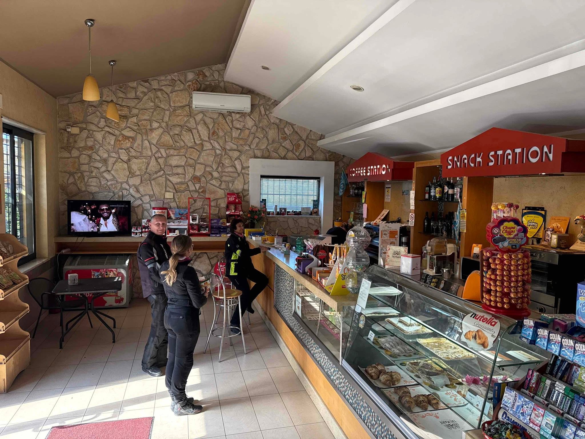 Motorradfahrer bei der ersten Cappuccino-Pause in einer italienischen Tankstelle